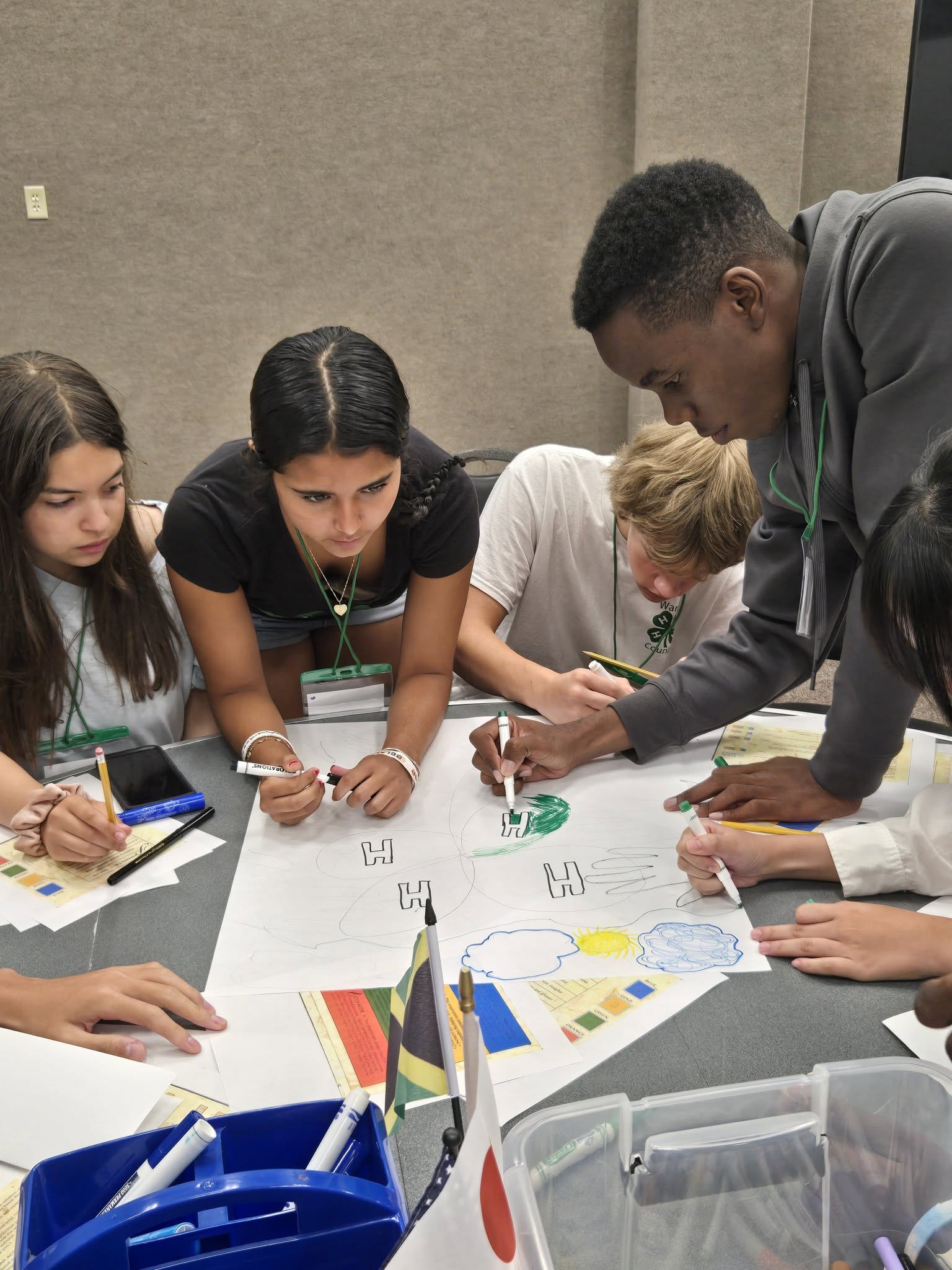 A group of youth leaning over a table working.